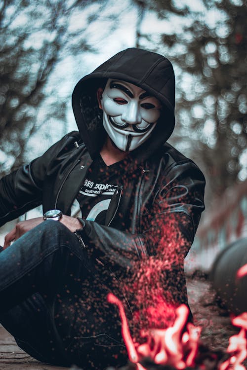 Person Wearing Guys Fawkes Mask Watching Flame
