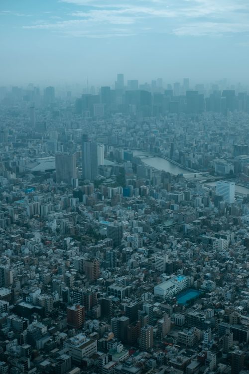 Free Foggy aerial view of cityscape showcasing urban density and modern architecture. Stock Photo