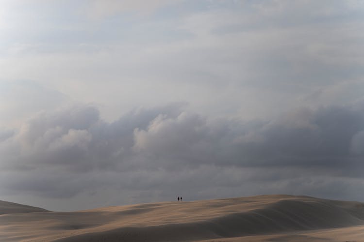 People Walking In The Desert In Distance