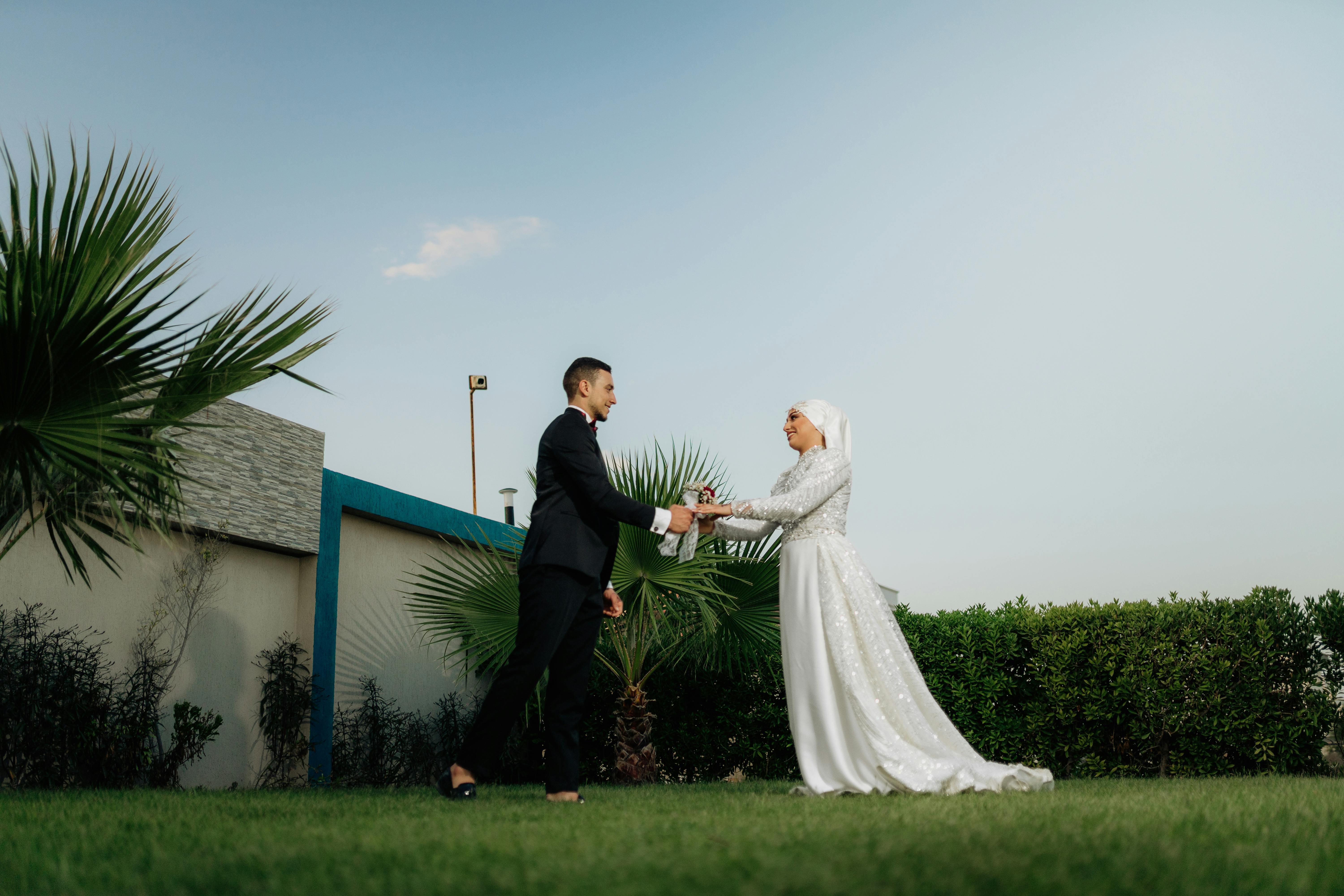 cheerful wedding couple stand on lawn