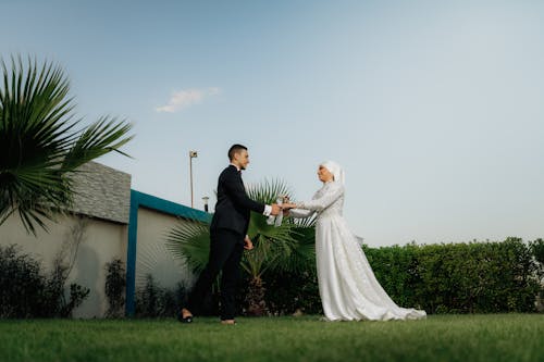 Cheerful Wedding Couple Stand on Lawn