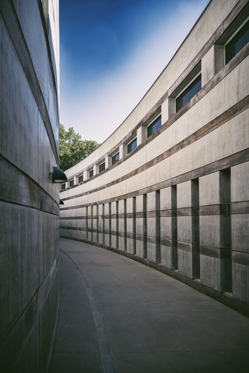 Free Serene urban alley between curved buildings under clear sky. Stock Photo