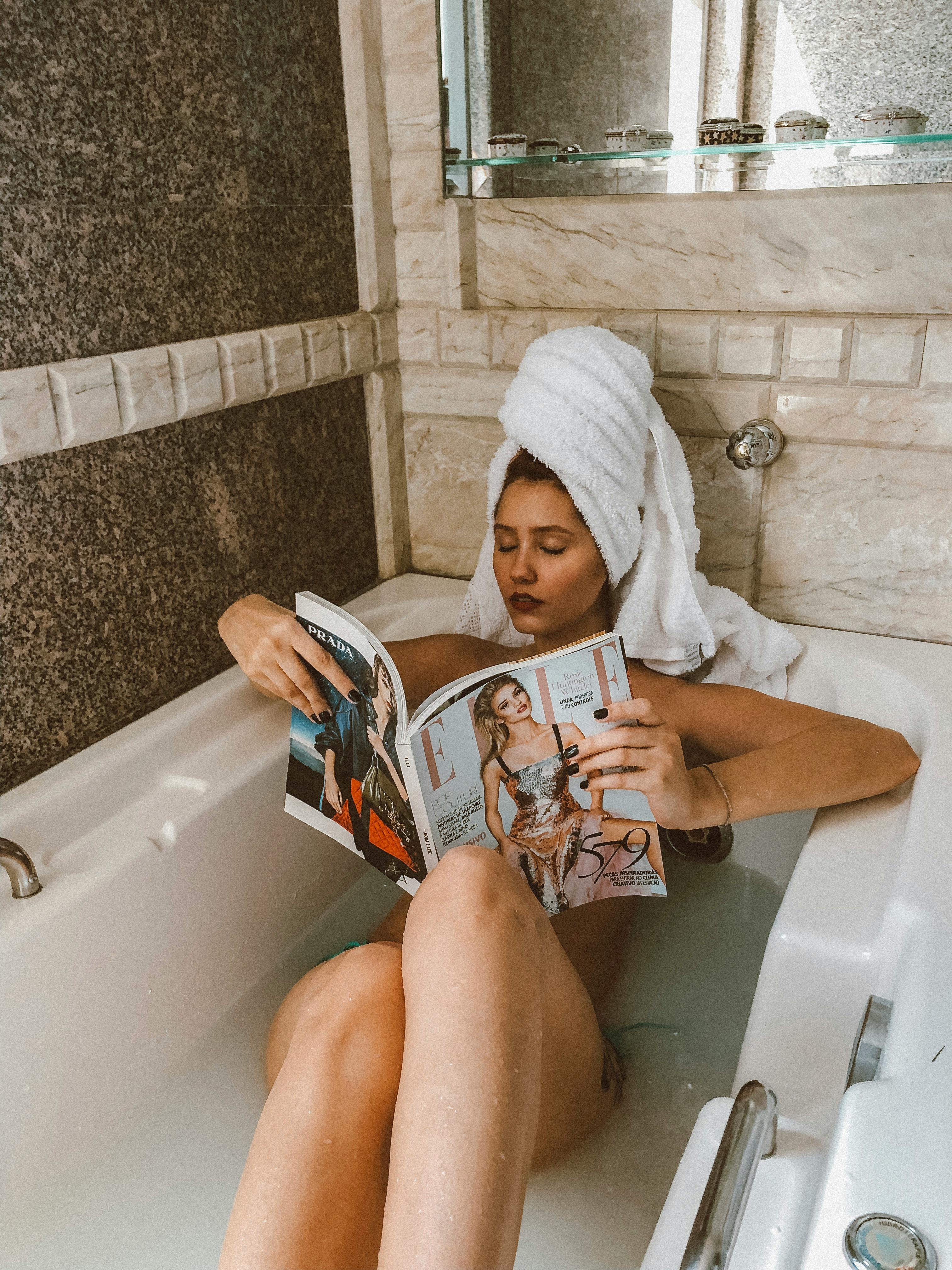 woman in bathtub reading magazine