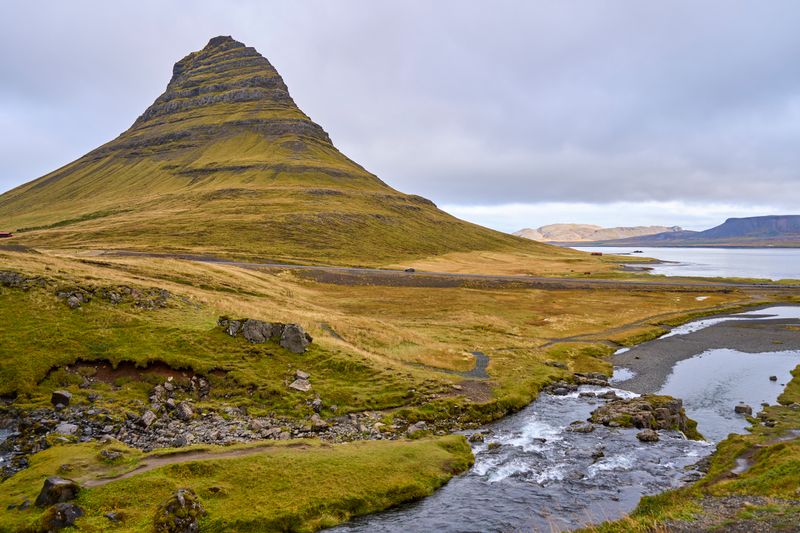 Kirkjufell mountain with a waterfall under dramatic Icelandic clouds