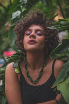 一幅宁静的女性肖像被郁郁葱葱的绿叶环绕，传达着自然的美丽与宁静