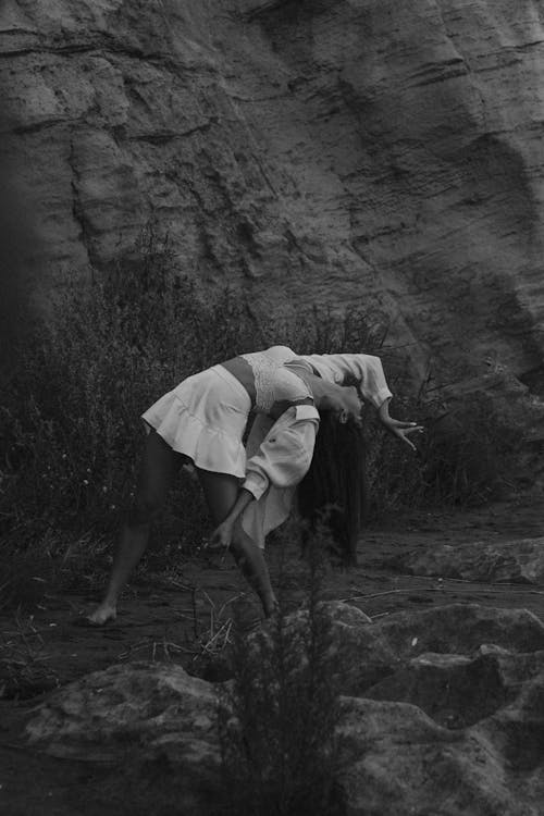 Model in Skirt Bending and Posing near Rocks