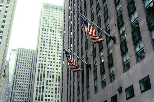 High-rise buildings with American flags in downtown New York City.