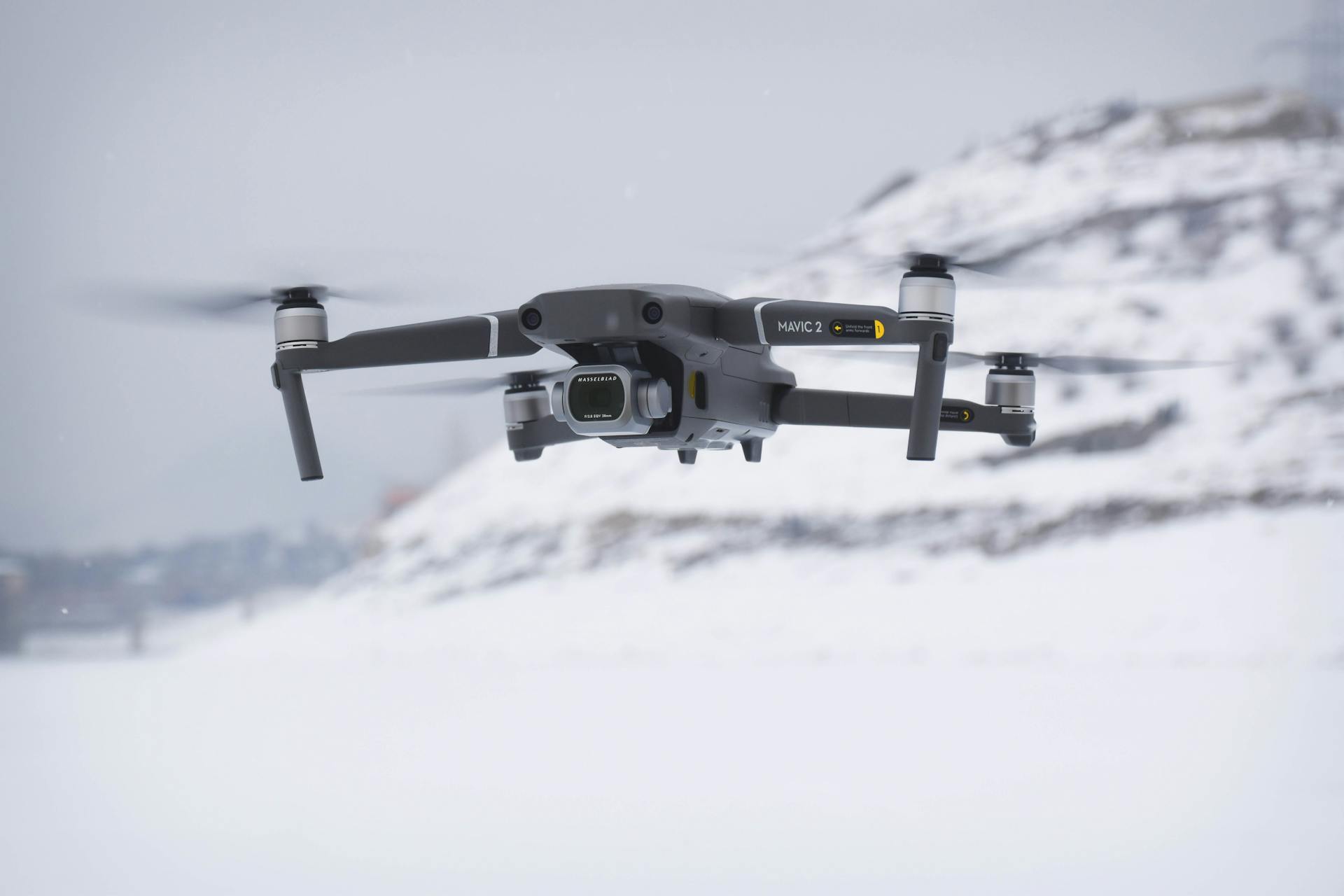 Close-up of a drone in flight over snowy terrain showcasing advanced technology.