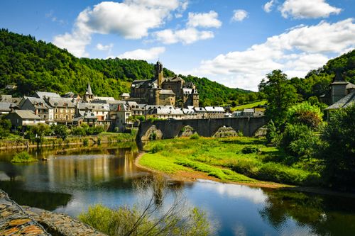 Free Explore the picturesque village of Estaing and its historic castle surrounded by lush greenery and a serene river. Stock Photo