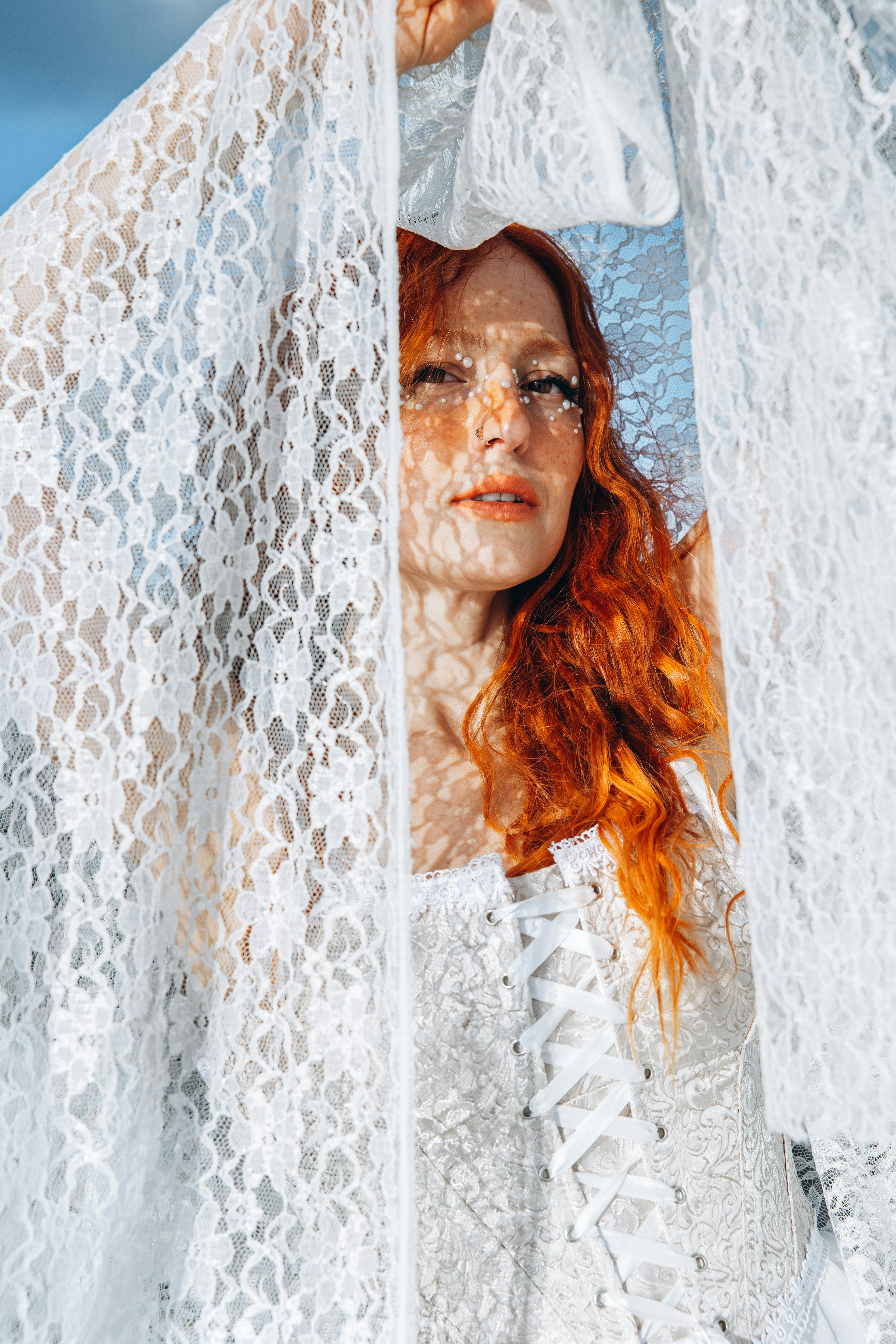 a woman with red hair and white lace dress