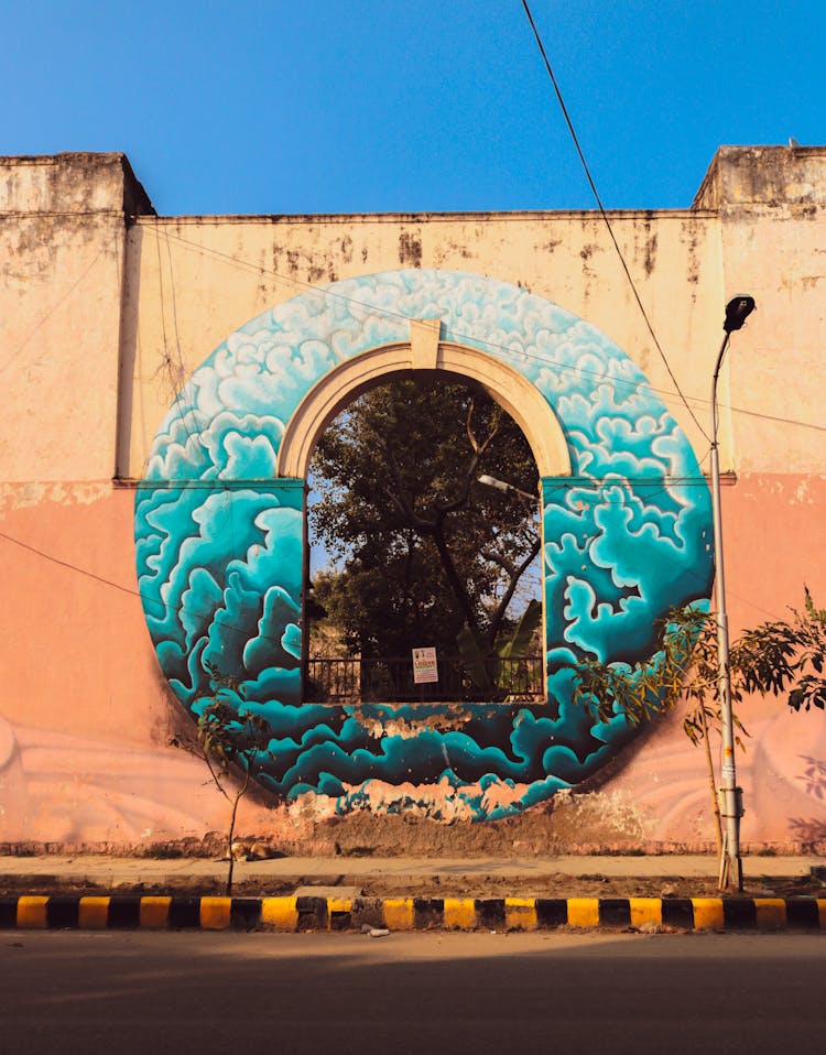 An Arched Window With A Mural On An Old Concrete Wall