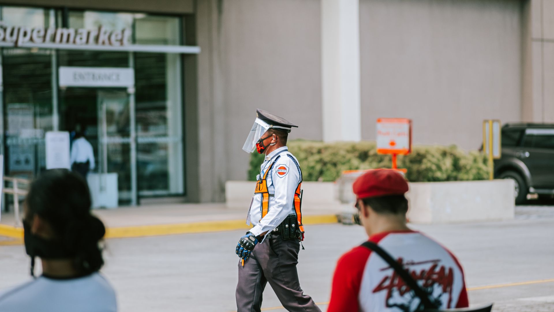 Modafinil for Security Guards: Enhancing Vigilance A security guard wearing protective gear walking outside a city supermarket entrance — modafinil for security guards
