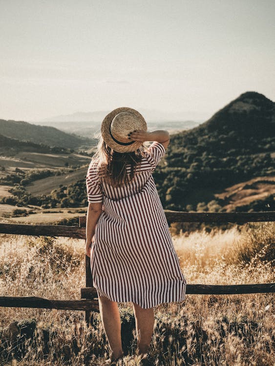 Selective Focus Photography of Woman Holding Brown Straw Hat