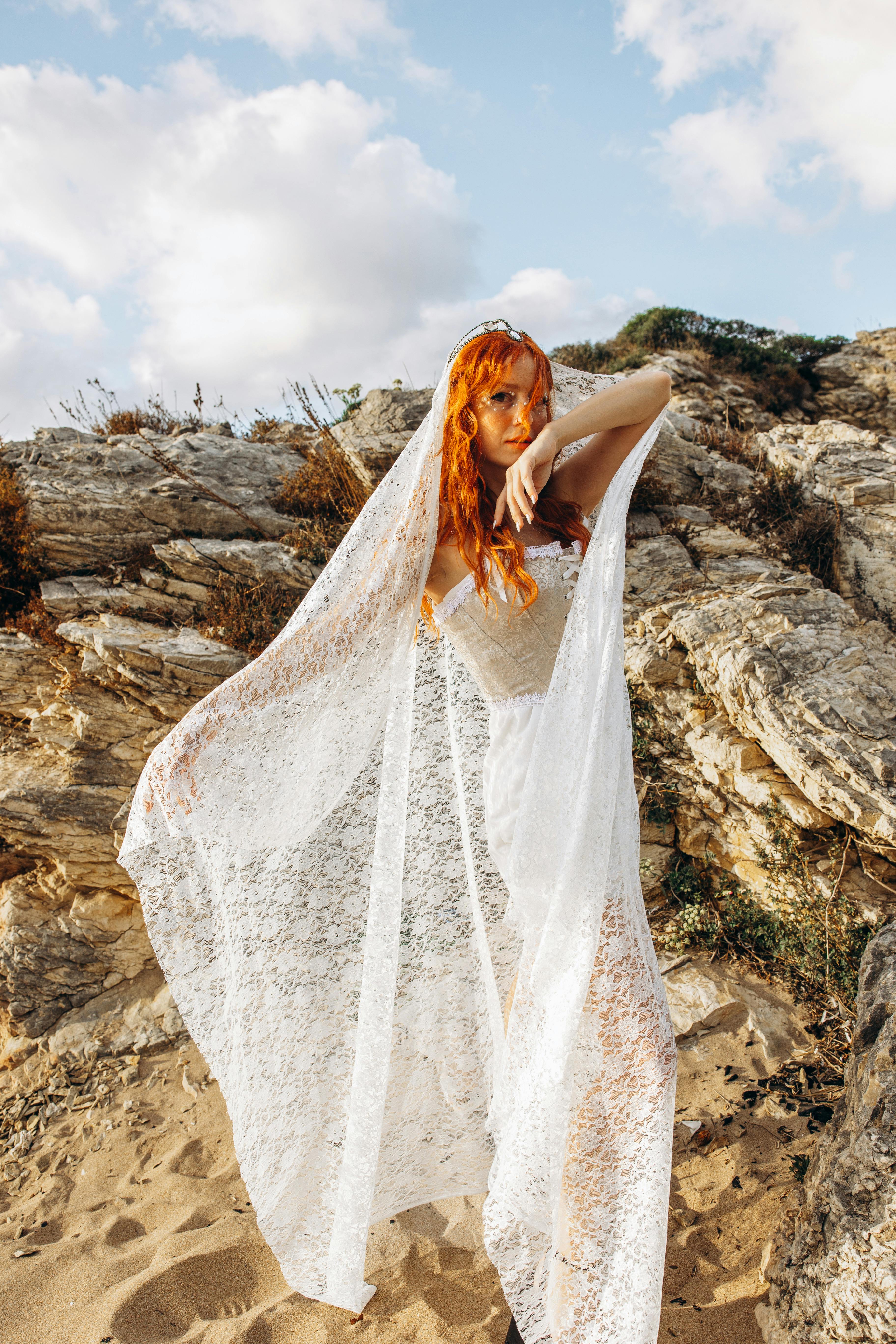 a woman in a white dress standing on the beach