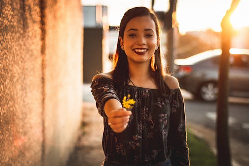 Smiling Woman Holding Yellow Petaled Flower