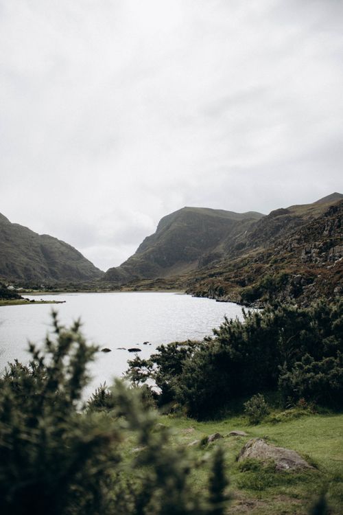 Free Breathtaking aerial view of a serene lake surrounded by lush hills and natural scenery. Stock Photo