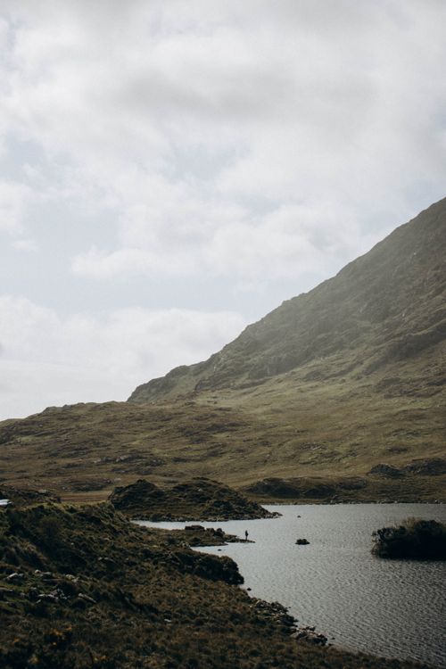 Free Tranquil mountainous landscape featuring a serene lake under a cloudy sky, perfect for travel inspiration. Stock Photo