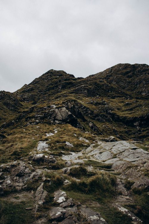 Free Explore the tranquil beauty of a rugged mountain landscape with rocks and sparse vegetation under a cloudy sky. Stock Photo