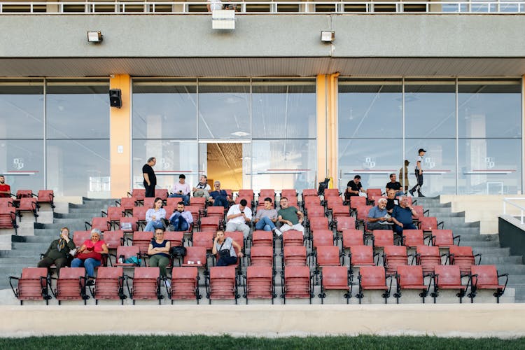 Group Of People Sitting On A Bench And Waiting