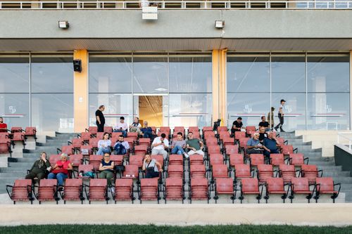 Free A sparsely occupied stadium grandstand with spectators seated, waiting for an event. Stock Photo