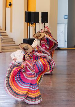 Vibrant folkloric dancers in colorful traditional attire performing in Tequila, Mexico.
