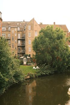 Charming view of riverside buildings and lush greenery in Aarhus, Denmark.