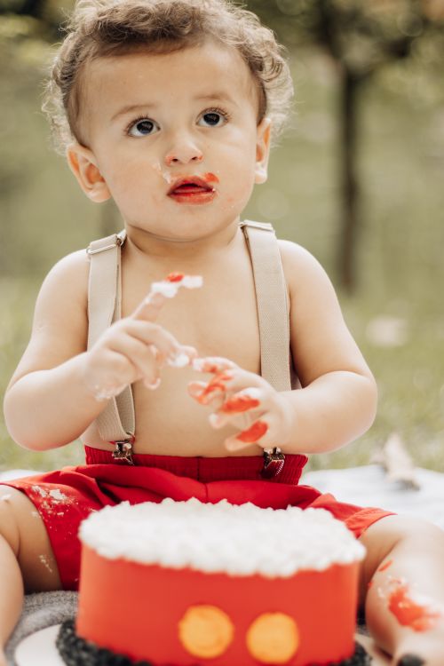 Free Cute baby enjoying birthday cake outdoors in São Paulo, Brazil. Stock Photo