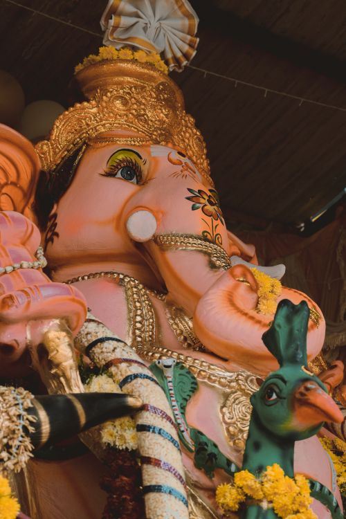 Free A detailed close-up of a colorful Ganesha statue adorned with floral decorations. Stock Photo
