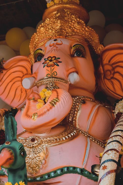 Free Close-up of an ornate Ganesha statue decorated with flowers, representing Hindu religious art. Stock Photo