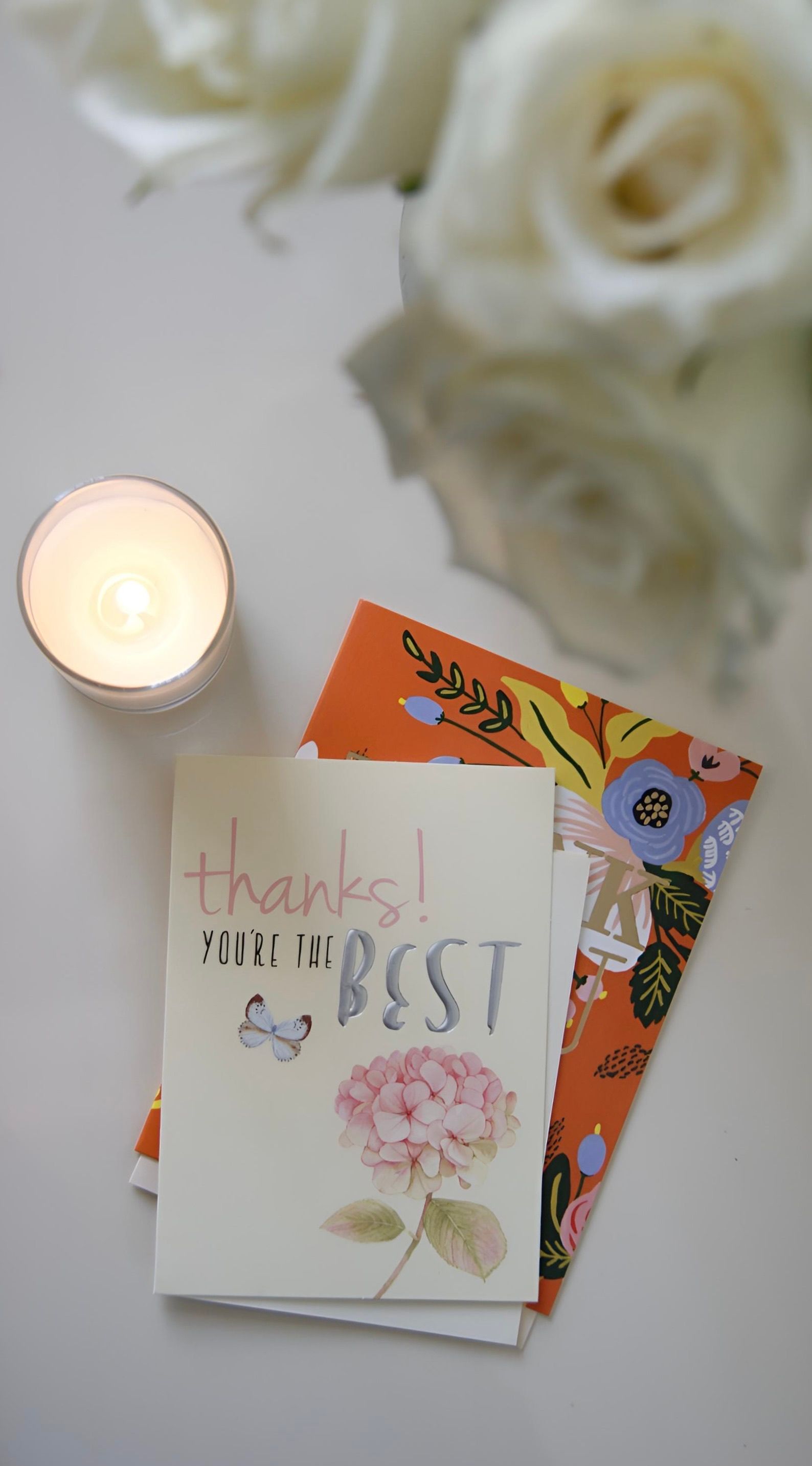 Delightful greeting cards with a candle and roses creating a warm ambiance.