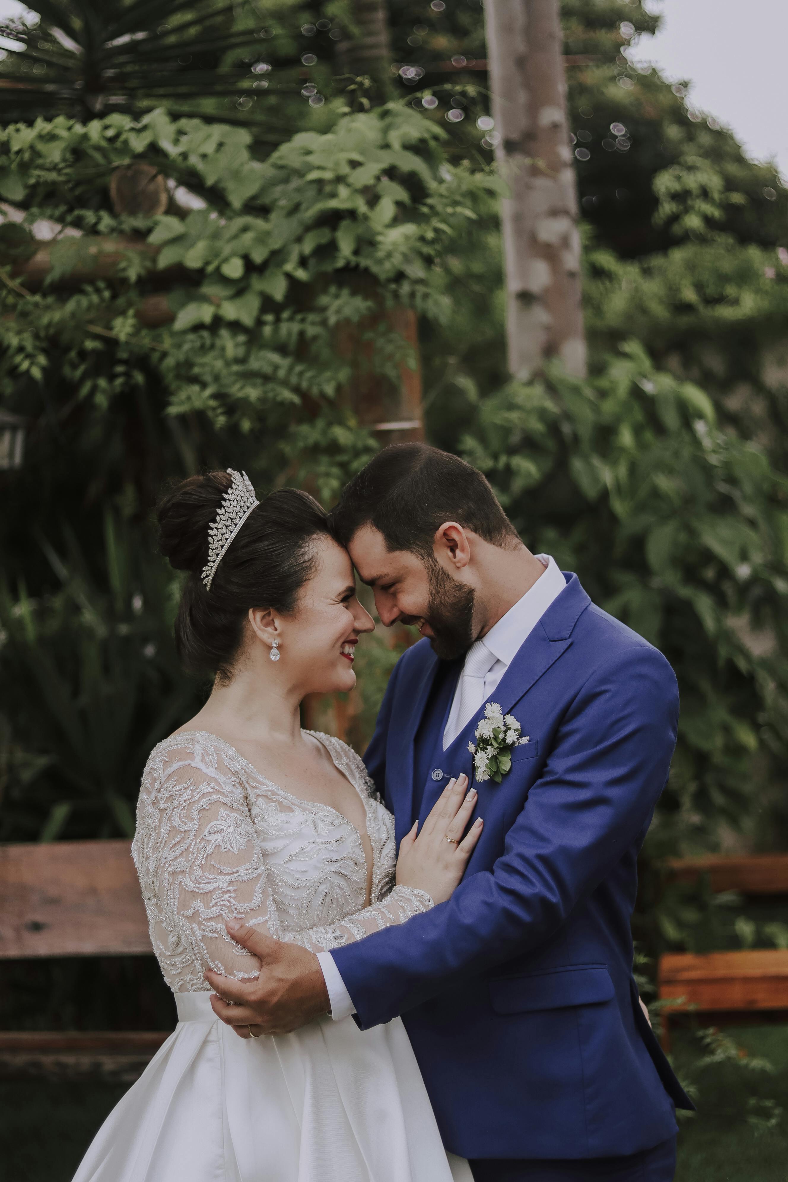 Newlyweds embrace in a lush garden setting, exuding joy and elegance.