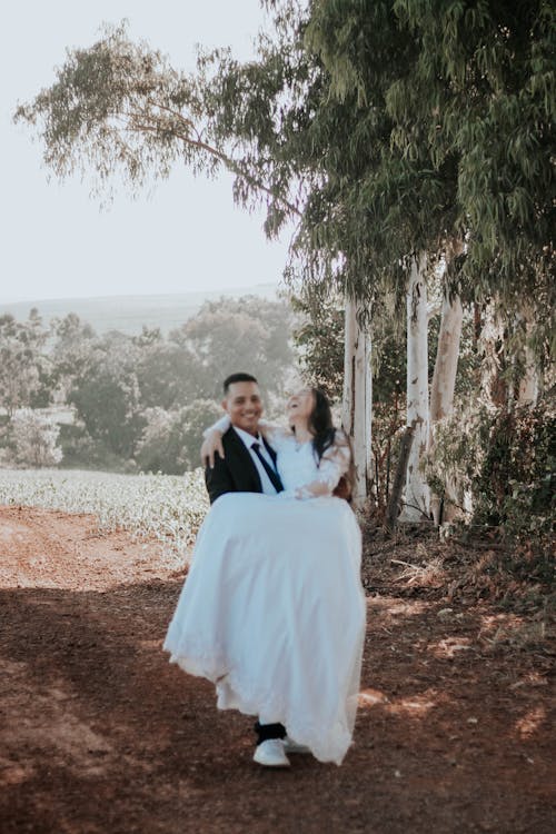 Smiling Newlyweds Posing on Dirt Road in Forest