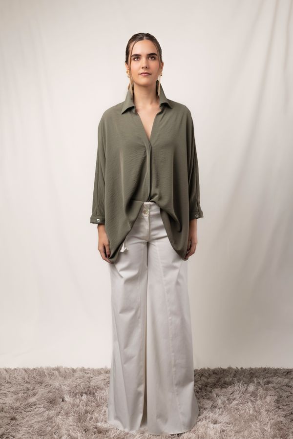 Model in an oversized shirt and wide-leg trousers on a studio backdrop, photo by Mauricio Casas on Pexels