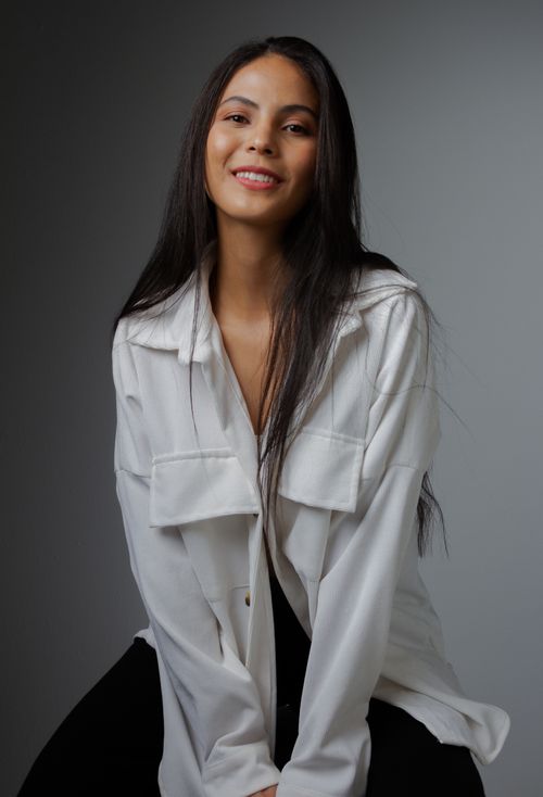 Free Portrait of a smiling woman in a white blouse, captured in a studio setting. Stock Photo