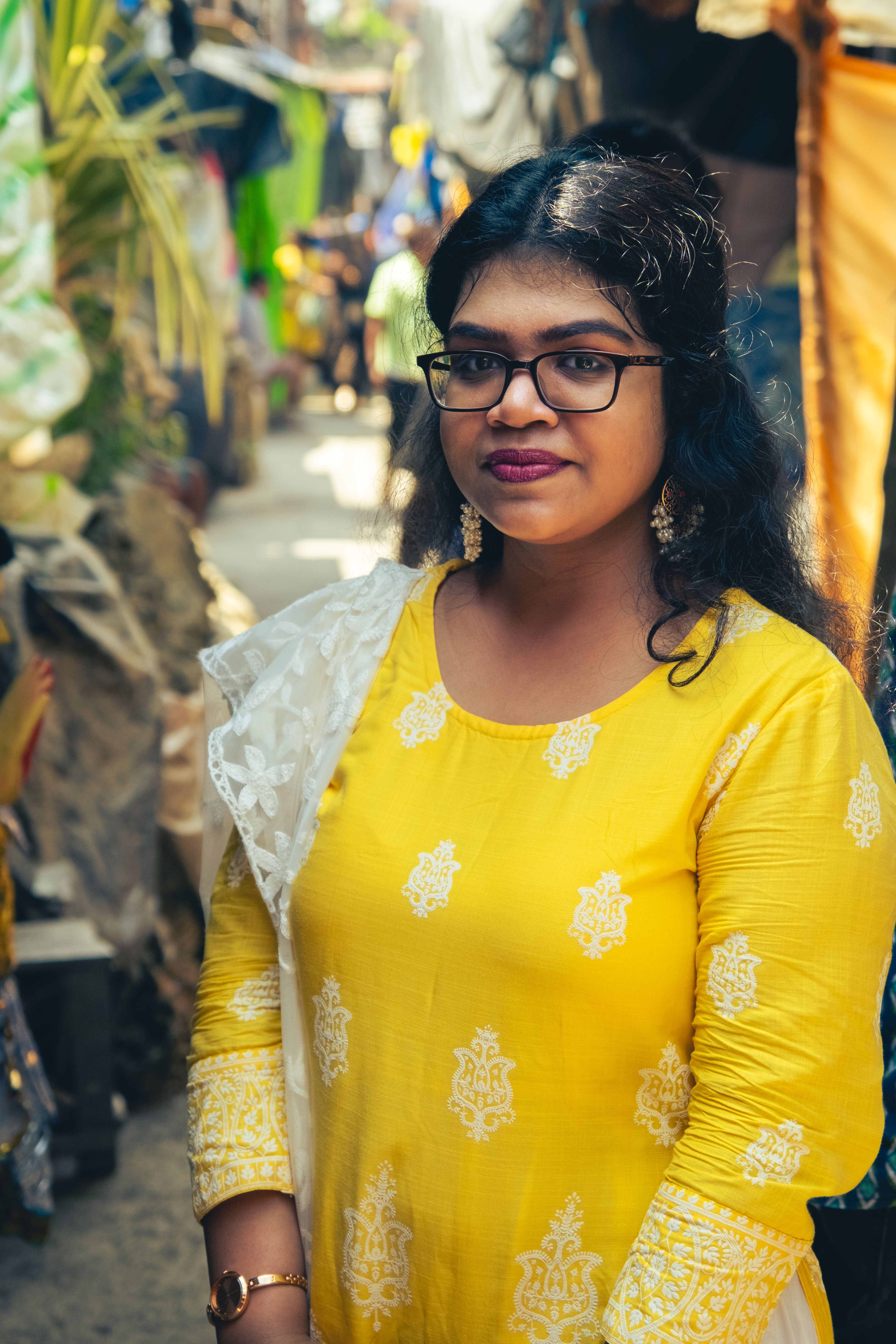 Indian woman in traditional yellow attire, Kolkata street, warm atmosphere, cultural vibe.