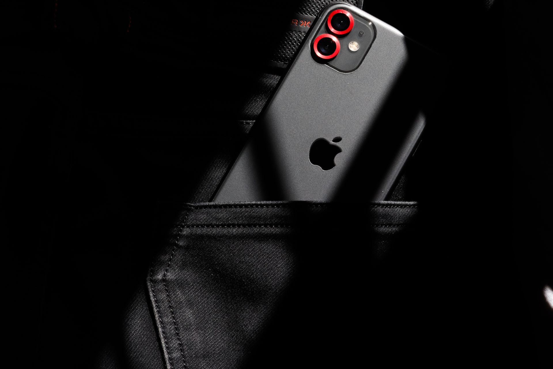 Gray IPhone Sticking from a Pocket of Black Jeans