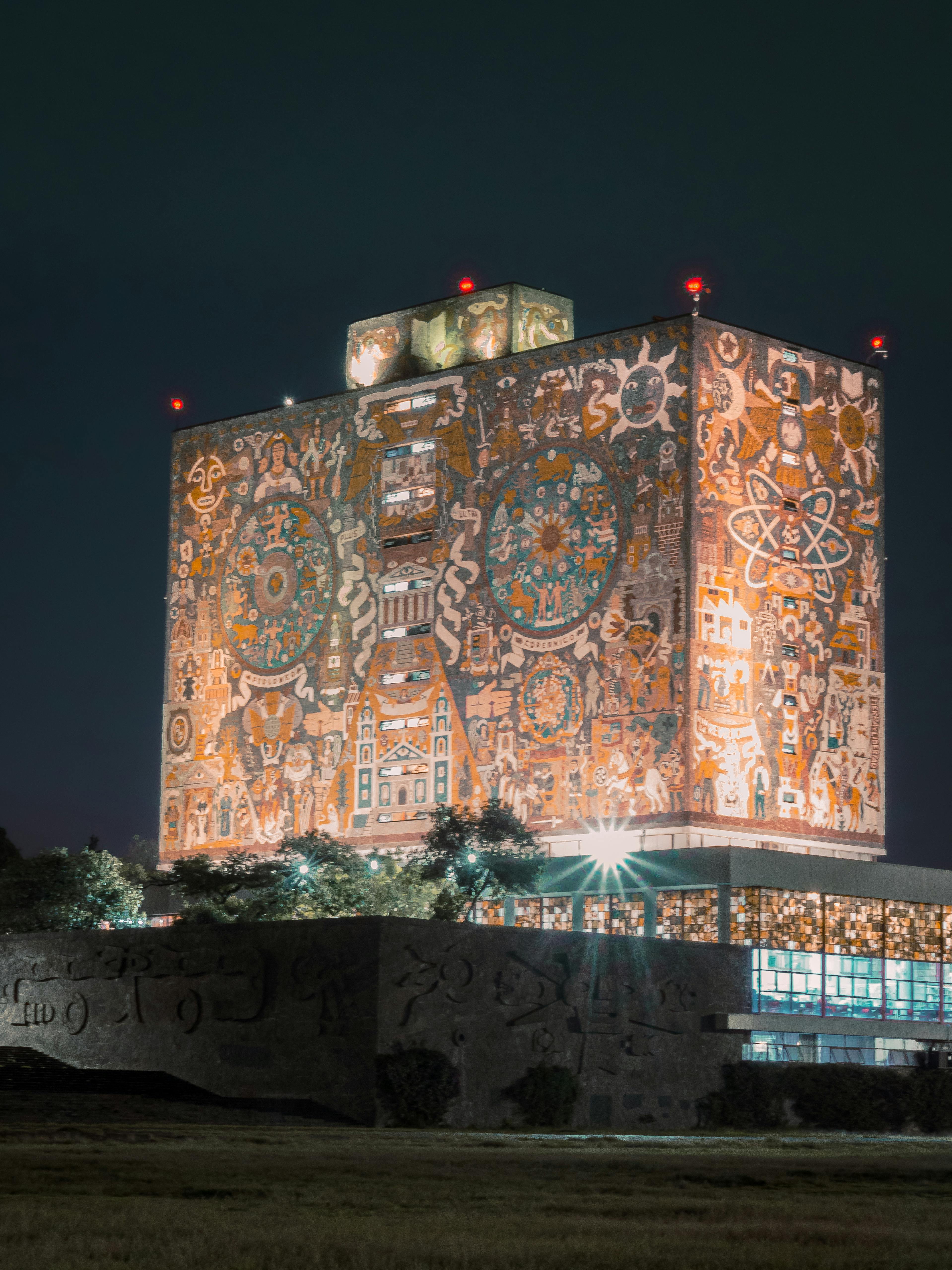 Stunning night view of UNAM library in Mexico City with iconic illuminated murals.