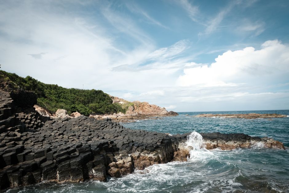 Discover the rocky shores of Thành phố Tuy Hòa with unique basalt formations and serene sea views.