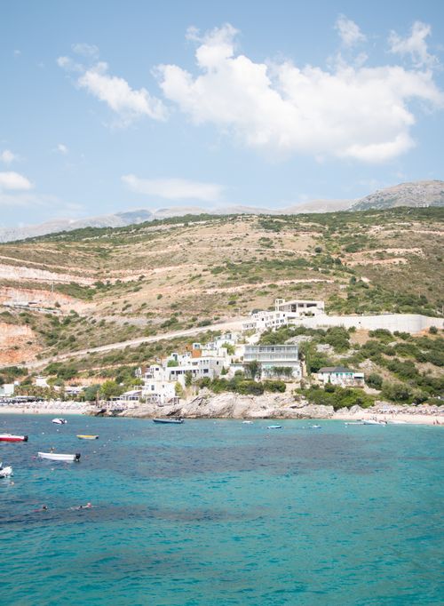 Free Aerial view of the serene coastline in Vlorë County, Albania, with hills and vibrant blue sea. Stock Photo