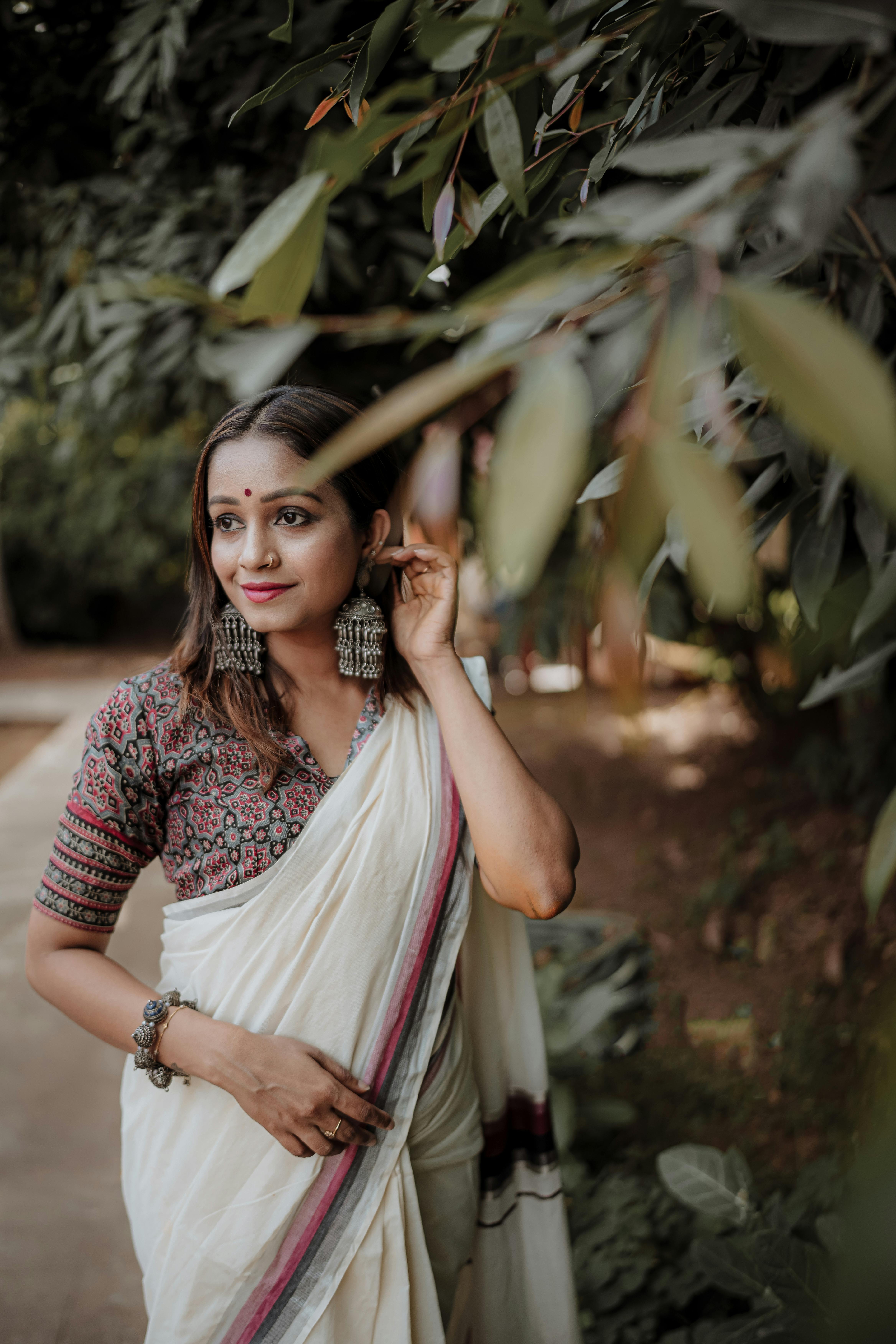 Free: Selective Focus Photo of Standing Woman in Saree Dress Posing With  Trees in the Background - nohat.cc