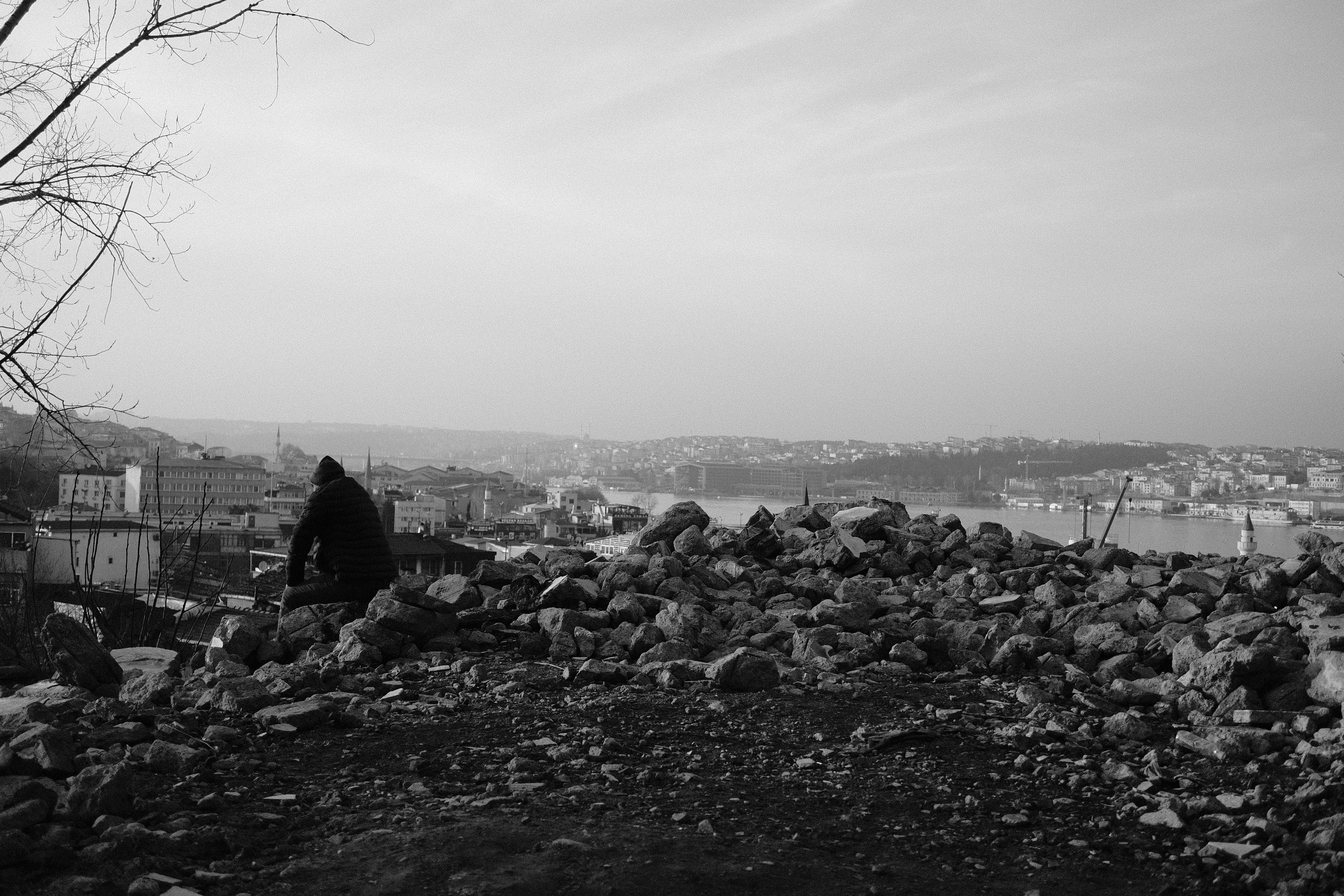 Man Sitting on a Stack of Rocks · Free Stock Photo