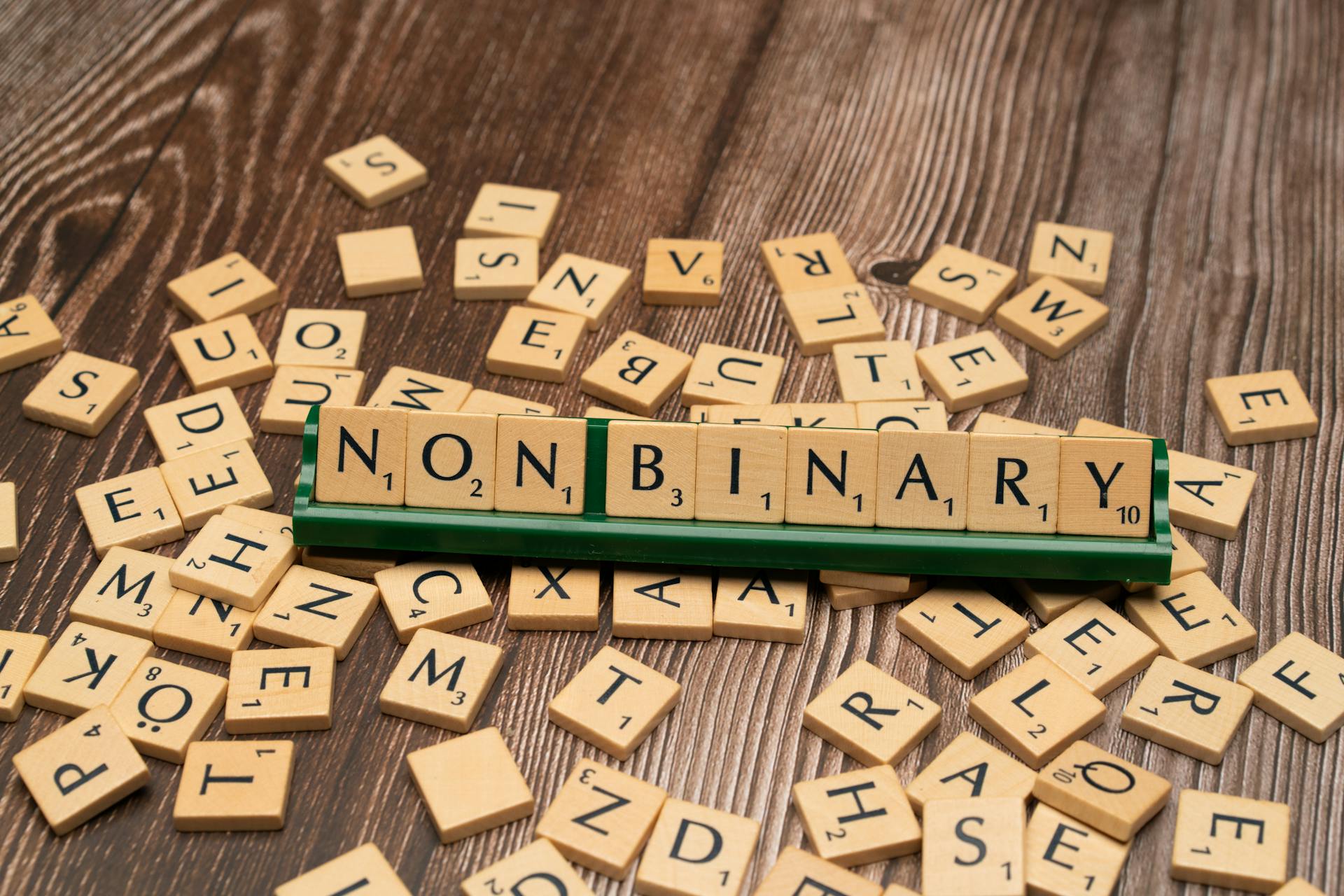 Wooden letter tiles spell 'Non Binary,' reflecting gender identity and inclusion.