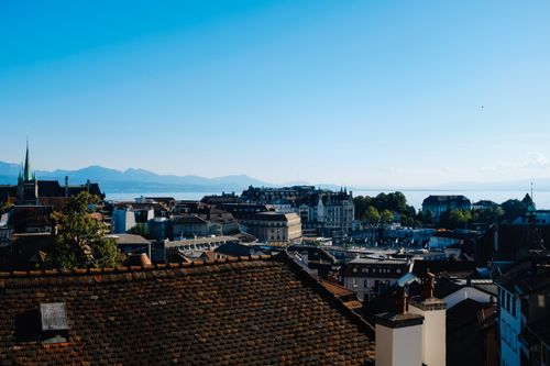 Free Breathtaking aerial view of a cityscape featuring rooftops with a mountain range in the background. Stock Photo