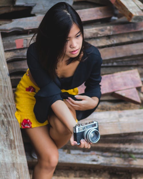 Woman Sitting on Stair While Holding Camera