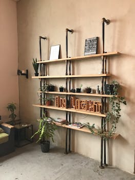 Contemporary industrial-style bookshelf with plants and decor in a cozy home interior.