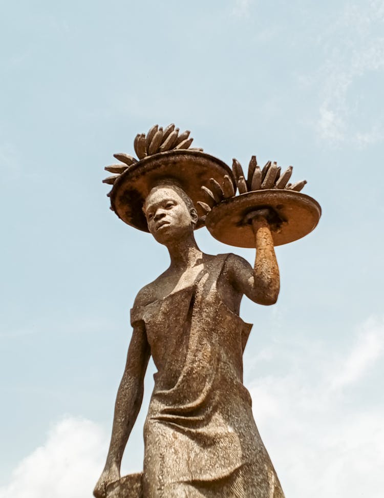 Statue Of Person Carrying Plates