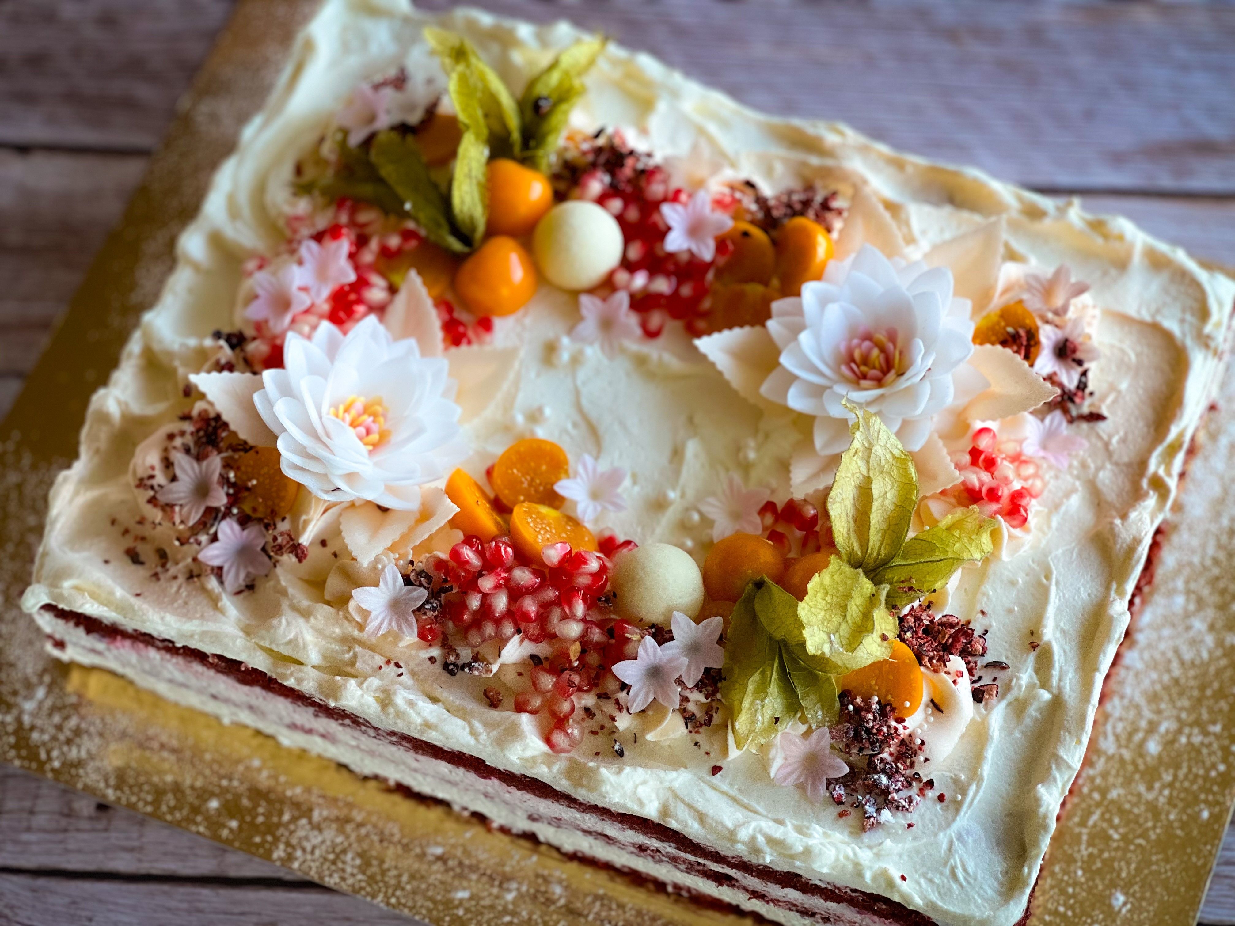 Cake decorated with various fruits and edible flowers