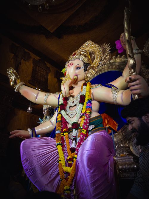 Free Colorful Ganesha statue adorned with flowers during a traditional Hindu festival celebration. Stock Photo