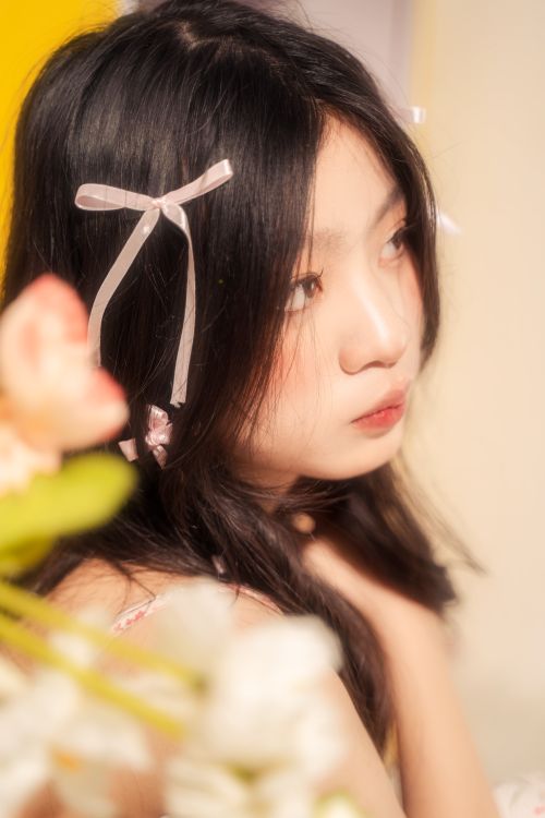 Free Gentle portrait of a young girl with flowers, featuring soft focus and a dreamy atmosphere. Stock Photo