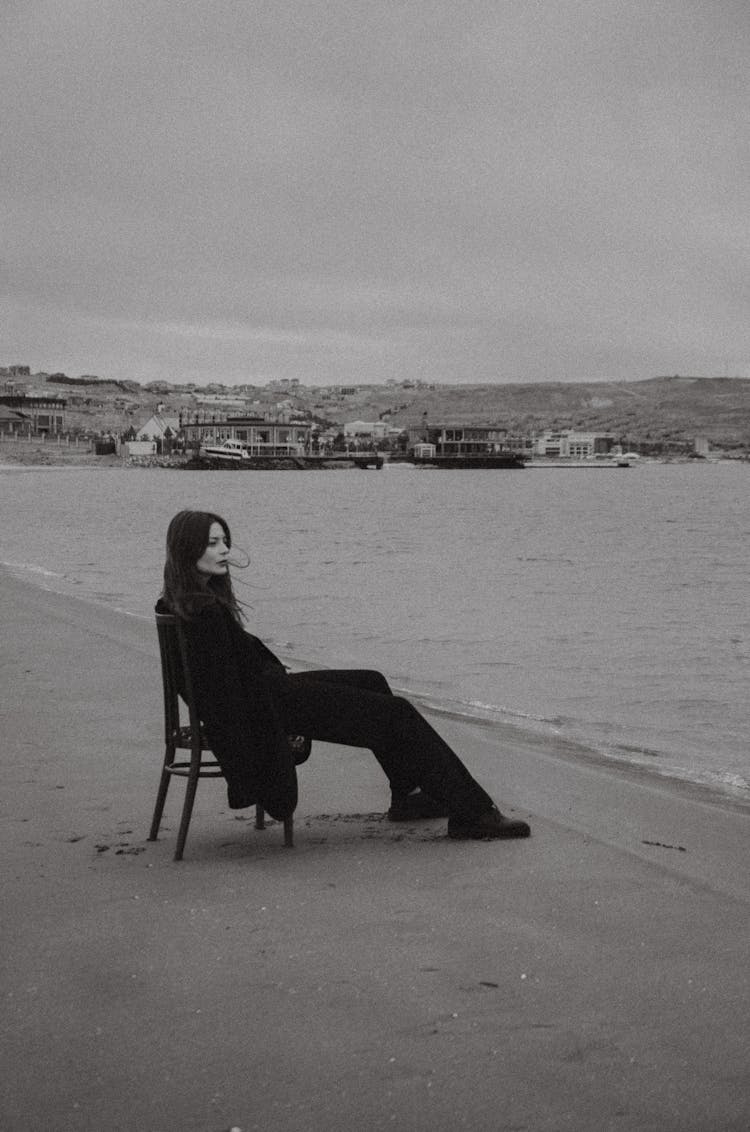 Woman Sitting On A Chair On A Beach 